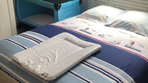 Een slaapkamer met een bed, een blauw ledikant en een dakraam.