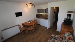 A compact kitchen with a dining area, a small refrigerator, and a microwave. - 100m from resort center, balcony, tv, ski locker, 21m², Tignes (Tignes)