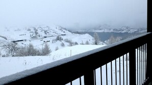 A snowy landscape with a lake and buildings in the distance. - 100m from resort center, balcony, tv, ski locker, 21m², Tignes (Tignes)