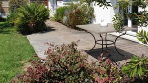 A modern house with a tiled roof, a paved patio, and a variety of plants. - 3-star Villa Nelson sleeps 6 3 bedrooms private pool (Moliets-et-Maa)