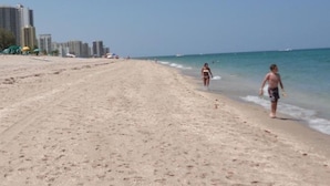 A beach with a clear sky, sandy shore, and buildings in the background. - PARADISE BY THE BEACH AND YOUR OWN PRIVATE POOL (West Palm Beach)