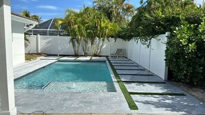 A rectangular swimming pool with clear blue water, surrounded by a white fence, and a lounge chair is visible in the background. - PARADISE BY THE BEACH AND YOUR OWN PRIVATE POOL (West Palm Beach)