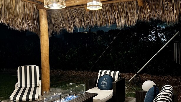 An outdoor seating area with wicker furniture, a fire feature, and hanging wicker lamps. - PARADISE BY THE BEACH AND YOUR OWN PRIVATE POOL (West Palm Beach)