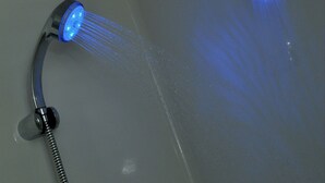 A shower with a blue light fixture. - Hotel Caspia Pro (Greater Noida)