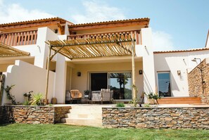 A two-story house with a covered patio, stone walls, and a balcony. - Relais et Châteaux Ile de la Lagune (Saint-Cyprien)