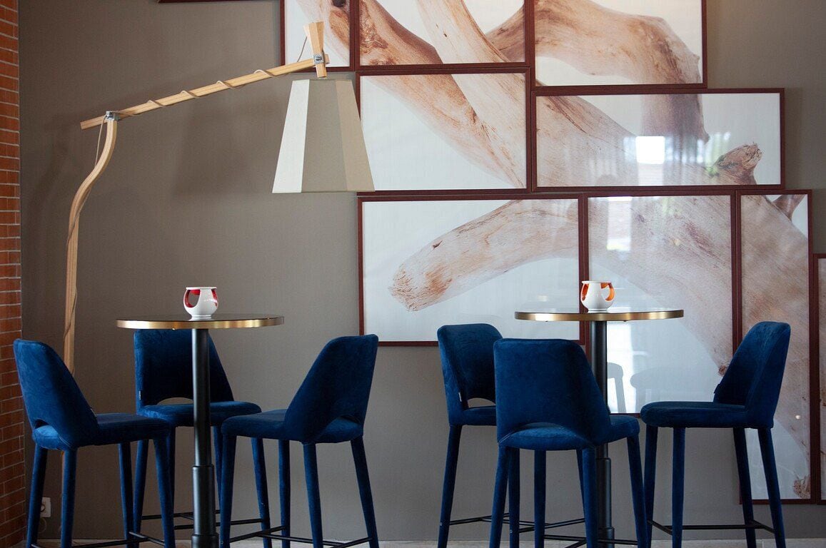A modern interior with a brick wall, a wooden shelf, and a table with chairs.
