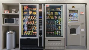 Un espace équipé d’un distributeur automatique proposant des collations, des boissons et un four à micro-ondes.