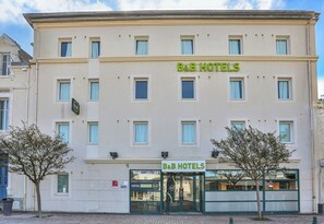 Un immeuble abritant un hôtel à plusieurs étages, avec une enseigne « B&B HOTELS » au-dessus de l’entrée.