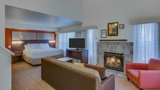 A hotel room with a bed, a TV, a fireplace, and a sofa. - Residence Inn By Marriott South Bend (South Bend)