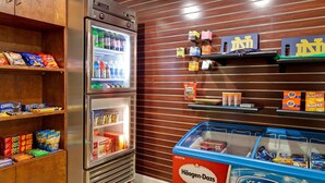 A snack bar with a refrigerator stocked with drinks and snacks, a freezer with ice cream, and shelves with packaged goods. - Residence Inn By Marriott South Bend (South Bend)