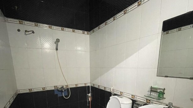 A bathroom with a toilet, sink, and shower. - Hong An Motel (Da Nang)