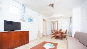 Una sala de estar moderna con televisor de pantalla plana, muebles de madera y un sofá.