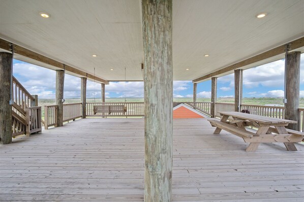 Enjoy a serene view from this outdoor deck with a bench and picnic tables.