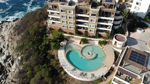 A coastal hotel with multiple balconies, a swimming pool, and solar panels. - Oceanview Punta Arrocito Luxury Condo, Near Arrocito Beach (Huatulco)