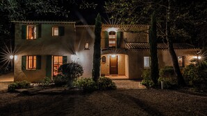 Una casa de dos pisos con una entrada bien iluminada y una puerta visible.