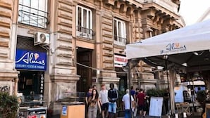 Un bâtiment historique à l’architecture remarquable, un établissement de luxe proposant des produits gastronomiques et des boissons de qualité, et une terrasse.