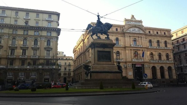 A statue on a pedestal in front of a building with classical architecture.