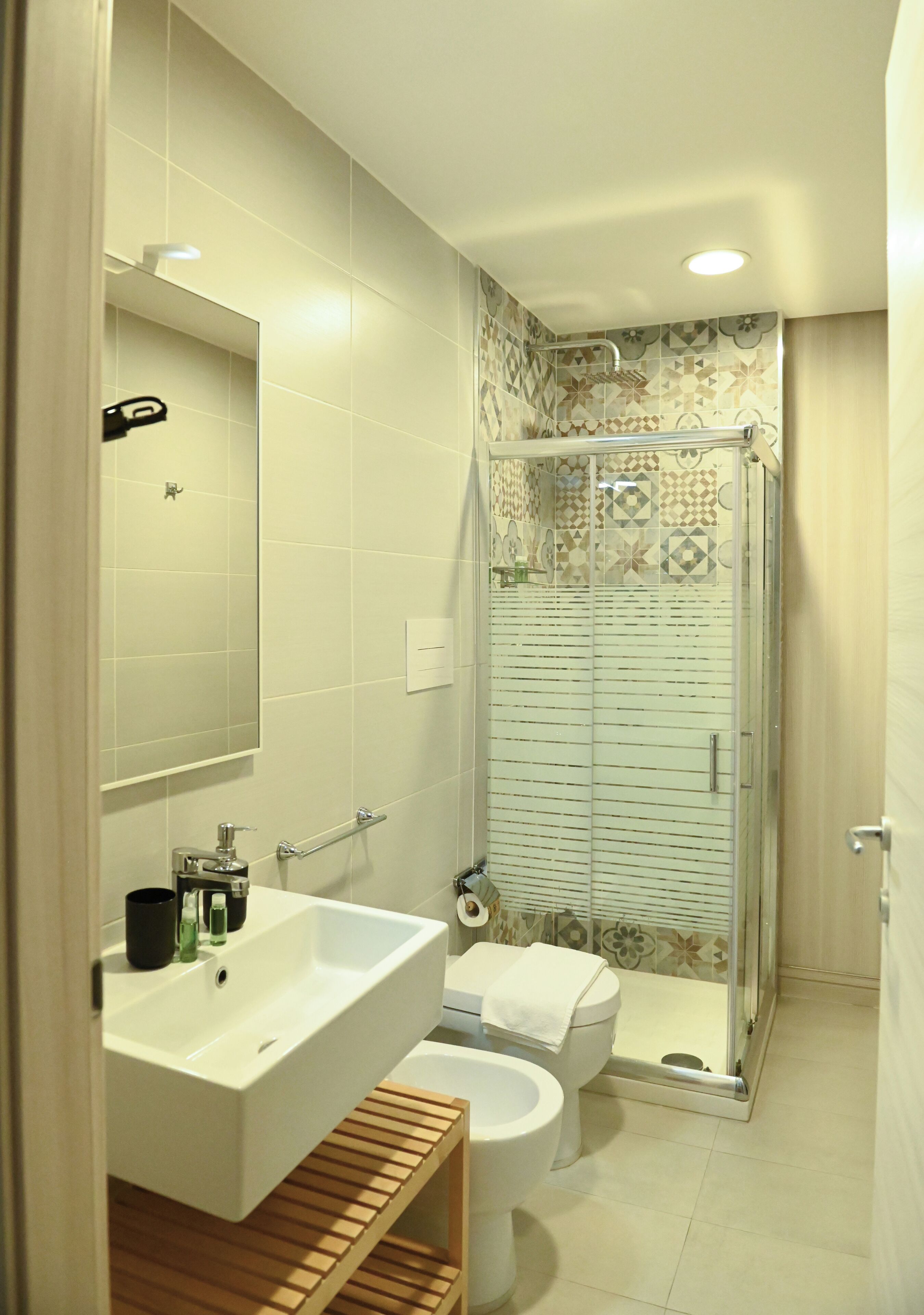 Une salle de bain avec un lavabo blanc, des toilettes et un espace douche.