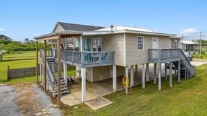 Ein zweistöckiges Haus mit überdachter Veranda und kleiner Terrasse.