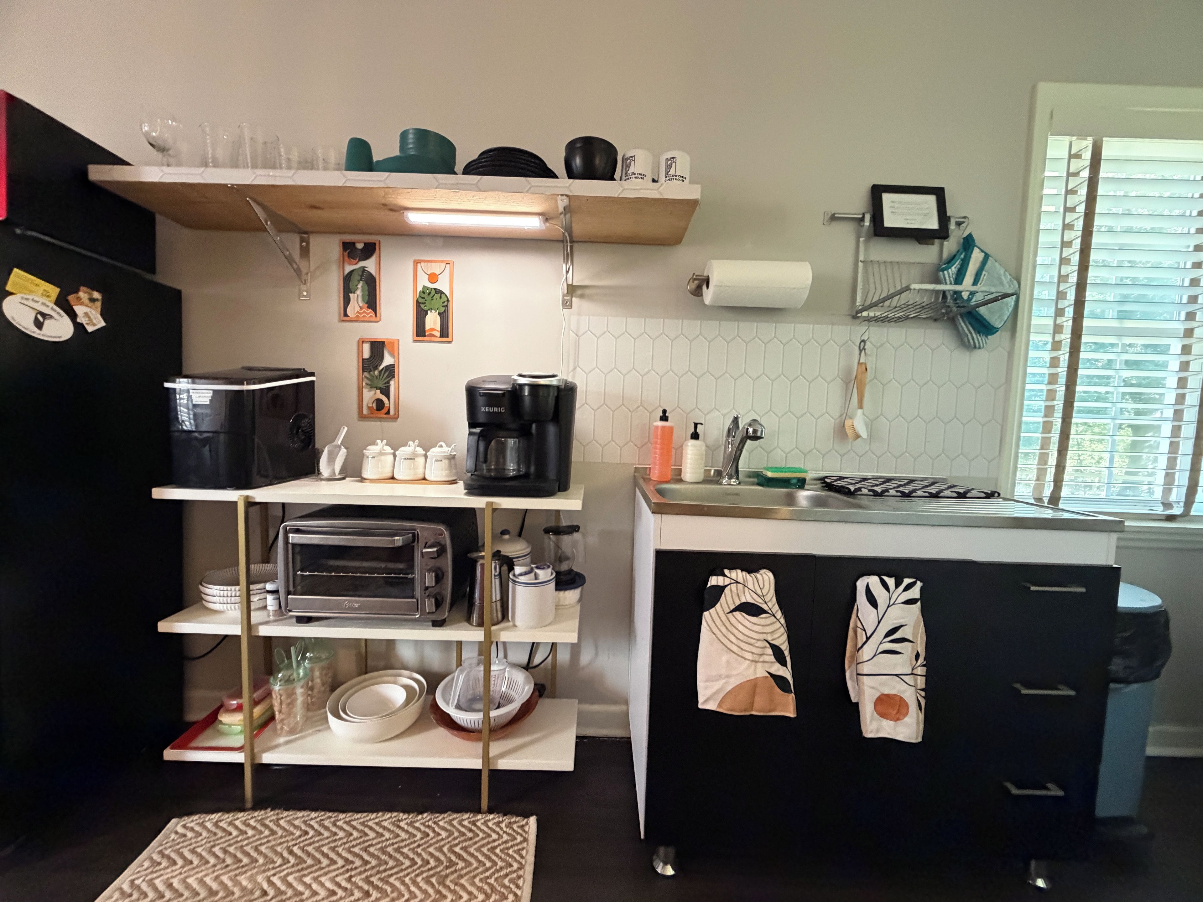 A compact kitchen with a built-in oven, a coffee maker, and a sink.