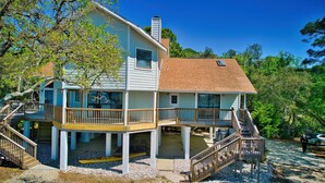 A two-story house with a balcony, a chimney, and a covered porch. - Secluded Waterfront Bay Home! (Eastpoint)