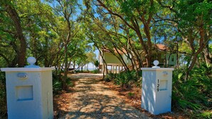 A pathway leading to a house surrounded by trees. - Secluded Waterfront Bay Home! (Eastpoint)
