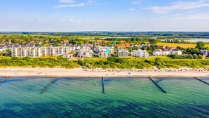 A coastal town with a beachfront, residential buildings, and a clear view of the sea. - Deichgraf 07, Direkter Meerblick aus Allen Drei Zimmern, 2 SZ, 2xbad, TG, Kamin (Börgerende-Rethwisch)