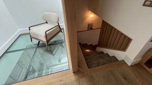 Moderni sisustus, jossa on lasilattia, joka johtaa portaikkoon.