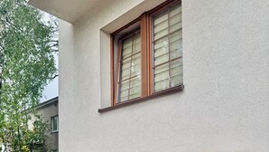 Un bâtiment avec une façade en briques, un cadre de fenêtre en bois et un auvent carrelé.