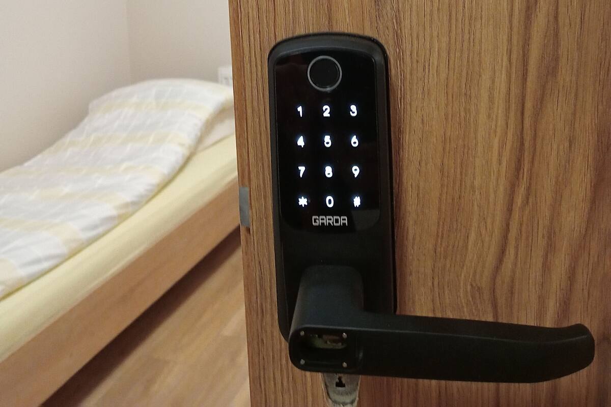 A wooden door with a black electronic lock.