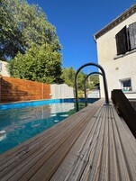 Una piscina al aire libre de temporada, tumbonas