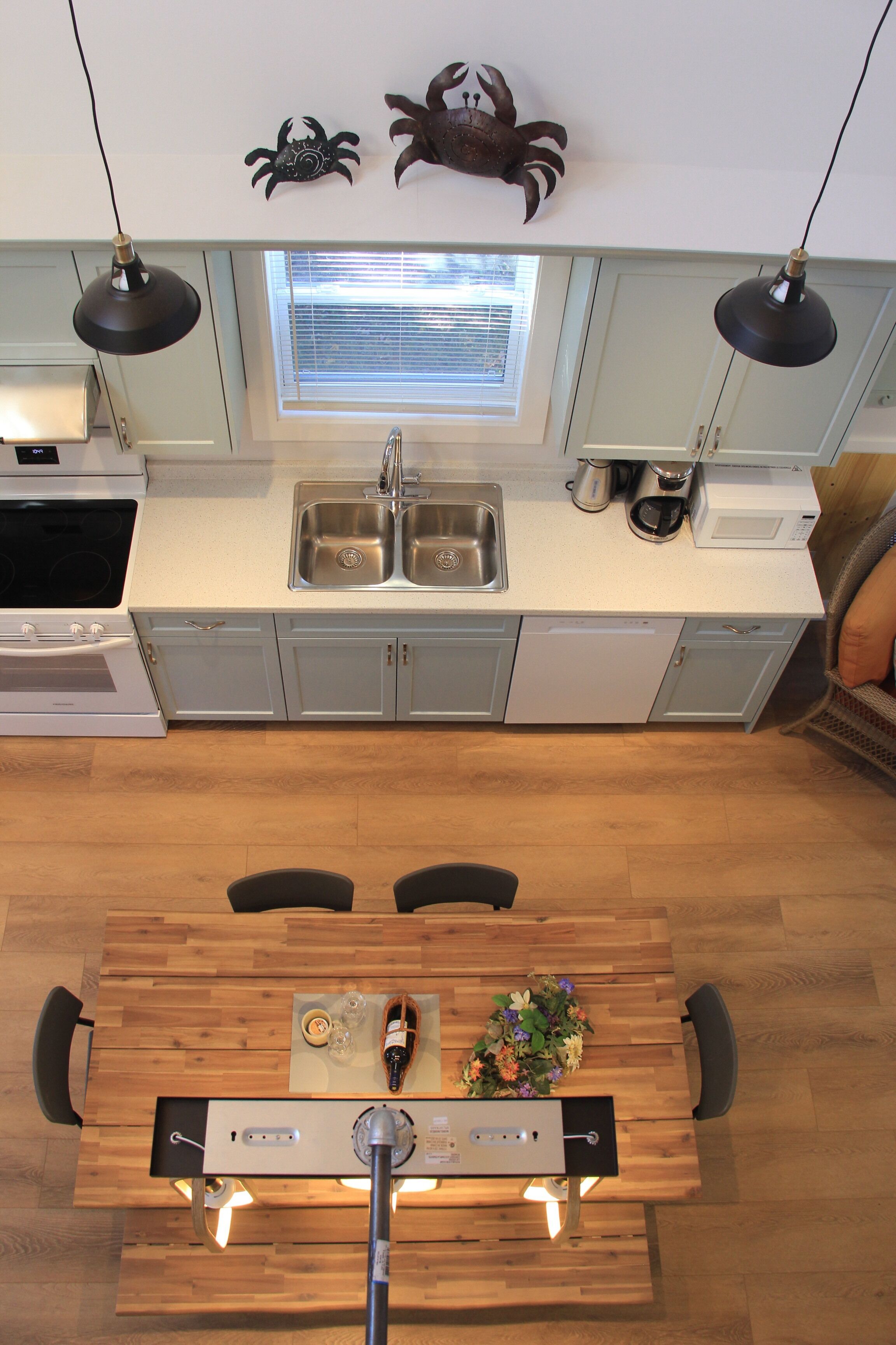 Una cocina moderna con un lavamanos doble, una estufa y un comedor con mesa de madera.