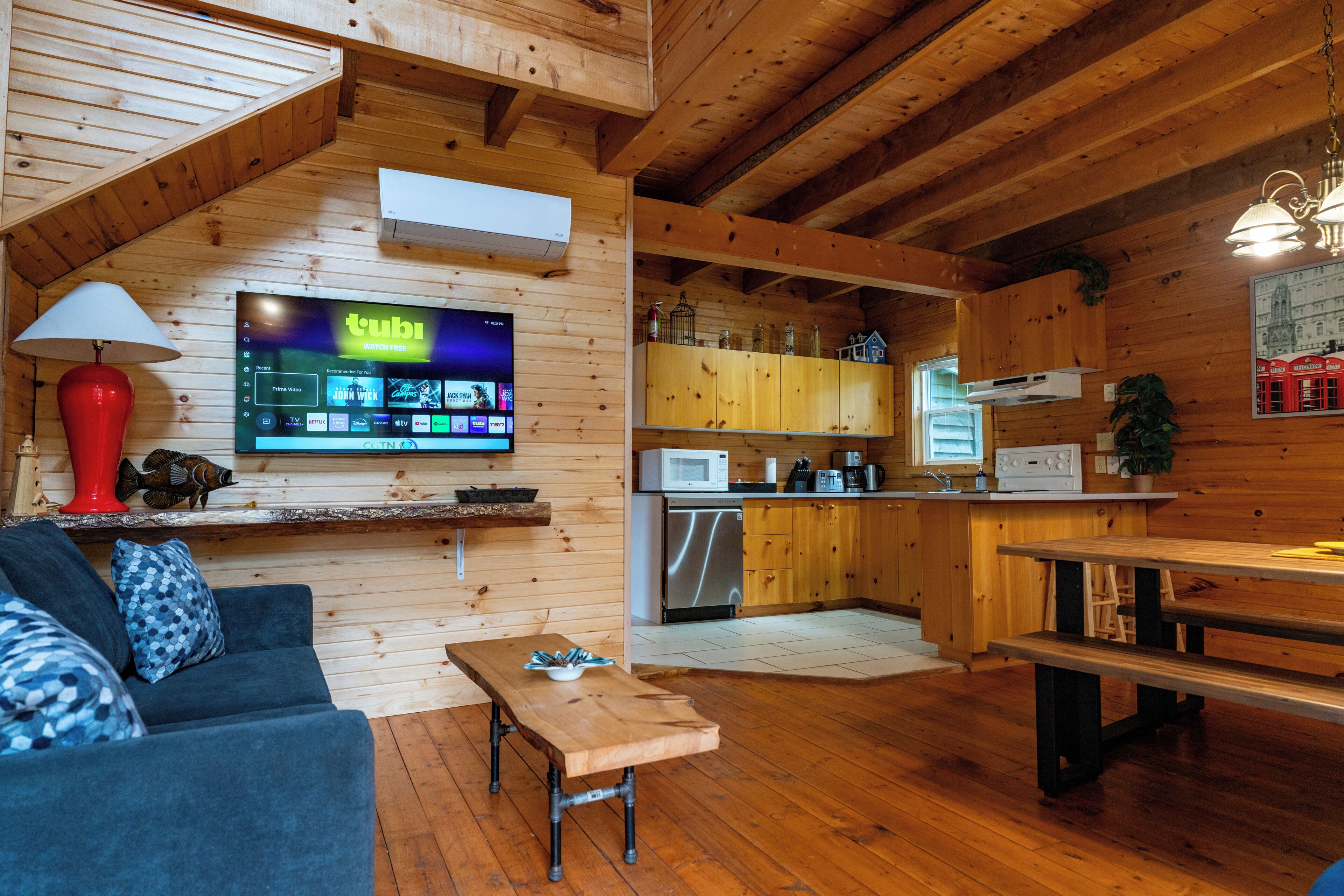 Un intérieur de chalet chaleureux comprenant un espace de vie, une cuisine et un coin repas.