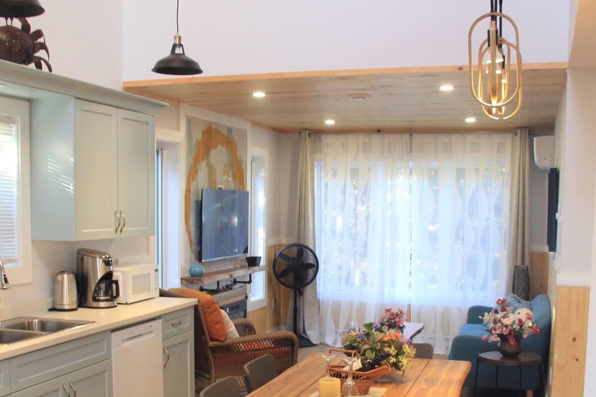 A modern kitchen with a wooden dining table, a built-in oven, and a microwave.