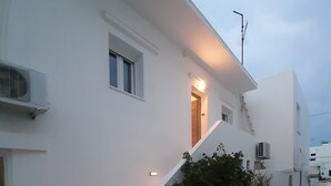 A white building with a stone staircase leading to a door. - Flora Rooms and Apartments Paros (Paros)