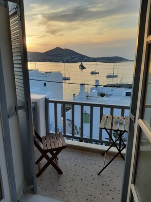 Un balcone con vista su barche sull'acqua, un tavolo e una sedia.
