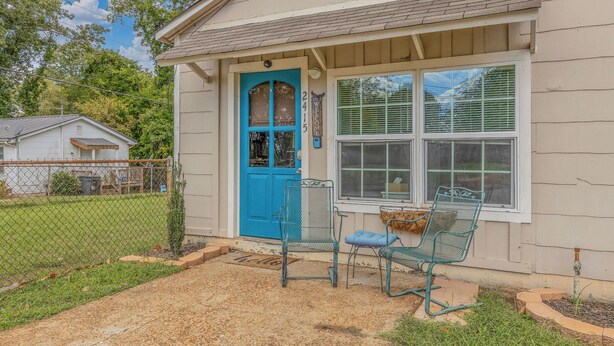 A house with a blue door, a porch with two metal chairs, and a small garden area. - Close to Hospital and Downtown, Eastside Bungalow, Dogs Welcome + Fee (Florence)