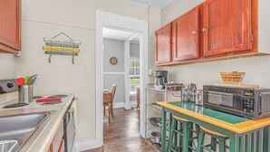 A kitchen with wooden cabinets, a microwave, a toaster, and a sink. - Close to Hospital and Downtown, Eastside Bungalow, Dogs Welcome + Fee (Florence)