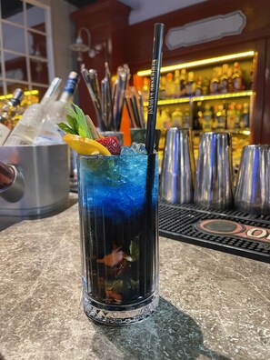Une ambiance de bar avec un verre à cocktail, des glaçons et une paille.