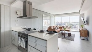 Un apartamento moderno con isla de cocina, comedor y sala de estar con vista a la ciudad.