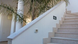 Uma escadaria com uma parede branca e uma pequena placa quadrada.