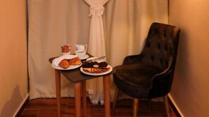 A small room with a table set for breakfast, a chair, and a curtain. - Sky pyramids  (Giza)