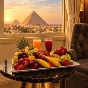 Una bandeja de frutas sobre una mesa, con vistas a las pirámides al fondo.