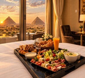 A hotel room with a breakfast tray, a view of the pyramids, and a sunset. - Sky pyramids  (Giza)