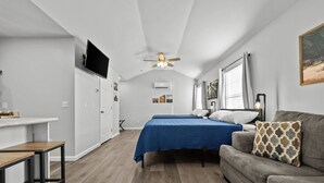 A bedroom with a bed, a sofa, a desk, and a ceiling fan. - "Live Oak" Cottage Reidsville Georgia (Reidsville)