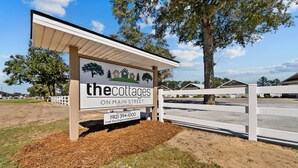 A sign for 'The Cottages on Main Street' with contact information. - "Live Oak" Cottage Reidsville Georgia (Reidsville)