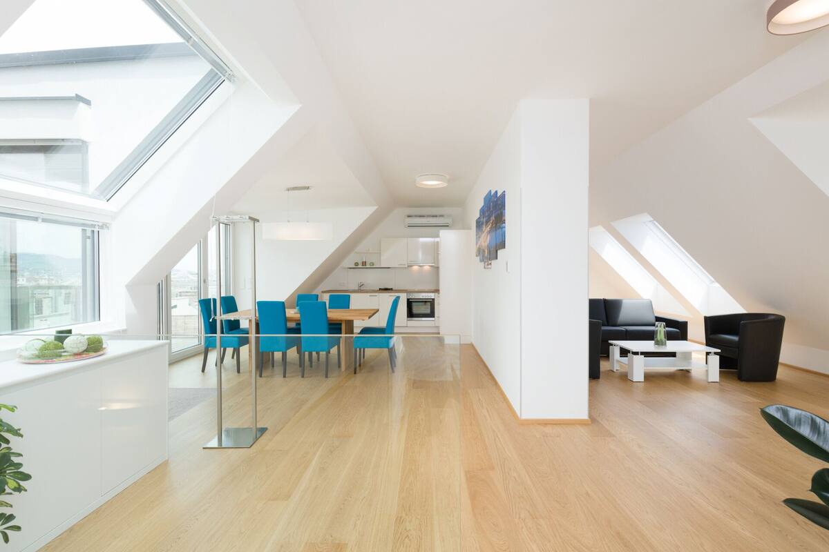 Um apartamento moderno com área de refeições, cozinha e sala de estar.