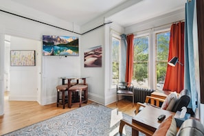 Una sala de estar moderna con un ventanal grande, un comedor y una zona de estar con vistas al exterior.
