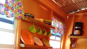 A kitchen with a sink, green dish rack, and shelves with plates and cups. - Salz Cozy Inn. Comfort at it's best. Peace is guaranteed! (Roseau Valley)