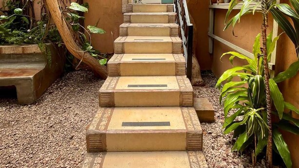 A staircase leading to a door with a view of a building in the background. - Gaudys Hotel (San José)